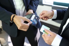 Khách hàng đi xe buýt điện có thể thanh toán tiền vé bằng thẻ chip ngân hàng. (Ảnh: VIetnam+) 
