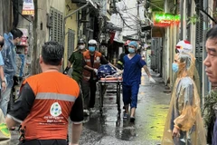 Lực lượng chức năng đưa các nạn nhân xấu số cuối cùng ra khỏi hiện trường. (Nguồn: Vietnam+ phát)