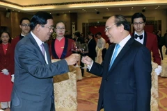 Thủ tướng Nguyễn Xuân Phúc chúc mừng Thủ tướng Vương quốc Campuchia Samdech Akka Moha Sena Padei Techo Hun Sen. (Ảnh: Phạm Kiên/TTXVN)