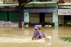 Đường Hùng Vương, thành phố Quy Nhơn bị ngập sâu, giao thông đi lại rất khó khăn. (Ảnh: Nguyên Linh/TTXVN)