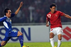 Tiền đạo Irfan Bachdim (phải), đội Indonesia trong pha tranh bóng với cầu thủ Kovanh Namthavixay, đội Lào. (Ảnh: AFP/TTXVN)