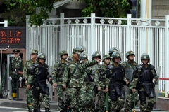 Cảnh sát bán quân sự Trung Quốc tuần tra một đường phố ở Urumqi, Tân Cương. (Nguồn: AFP)
