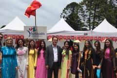 Đại sứ Việt Nam tại Argentina Nguyễn Đình Thao chụp ảnh ảnh các bạn biểu diễn áo dài tại sự kiện. (Ảnh: Phương Lan/Vietnam+)