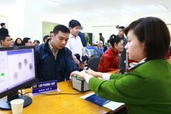 Cán bộ, chiến sỹ công an làm thủ tục lấy dấu vân tay công dân đến đăng ký cấp thẻ căn cước công dân. (Ảnh: Doãn Tấn/TTXVN)