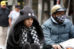 Ra đường ngày này sẽ thấy đủ các mốt thời trang chống rét. (Ảnh: Nhật Anh/TTXVN)