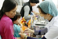 Nhân viên y tế tiêm chủng cho trẻ em. (Ảnh: TTXVN) 