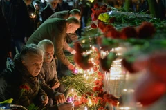 Người dân Ukraine thắp nến và đặt hoa tại tượng đài các nạn nhân của thảm họa Chernobyl tại Slavutich. (Nguồn: AFP/TTXVN)