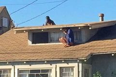 Một người phụ nữ leo lên mái nhà để trốn kẻ lạ mặt đột nhập