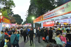 Phố sách Hà Nội Xuân Bính Thân thu hút sự chú ý của đông đảo độc giả. (Ảnh: TTXVN)