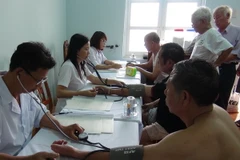 Nhân viên y tế kiểm tra sức khỏe cho các cựu chiến binh trước khi xông hơi, giải độc. (Ảnh: Nguyễn Hoài Nam/TTXVN)