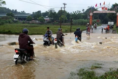 Các phương tiện tham gia giao thông khó khăn khi ngầm tràn bị ngập nặng. (Ảnh: Quốc Khánh/TTXVN)