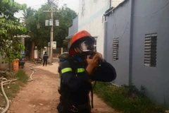 Chiến sỹ Cảnh sát phòng cháy chữa cháy đeo mặt nạ chống khí độc tiếp cận hiện trường. (Ảnh: Nguyễn Văn Việt/TTXVN)