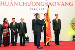 Chủ tịch nước Trần Đại Quang trao tặng Huân chương Sao Vàng cho Liên hiệp các Hội Văn học nghệ thuật Việt Nam. (Ảnh: Nhan Sáng/TTXVN)