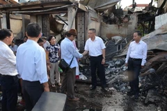 Đại sứ Vũ Quang Minh (thứ hai từ phải sang) đến thị sát và thăm hỏi kiều bào sau vụ cháy. (Ảnh: Nhóm PV TTXVN thường trú tại Campuchia)