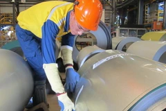 Công nhân nhà máy đang đóng gói thành phẩm thép mạ. (Ảnh: Hồng Nhung/TTXVN)