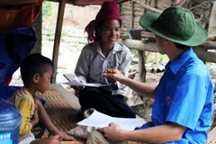 Cán bộ y tế dự phòng đến từng nhà hướng dẫn cách sử dụng thuốc khử khuẩn nguồn nước uống, nước sinh hoạt cho người dân. (Ảnh: Diệp Anh/TTXVN)