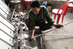 Nông dân Vũ Văn Dung hướng dẫn sử dụng máy cấy. (Ảnh: Hải Yến/TTXVN)