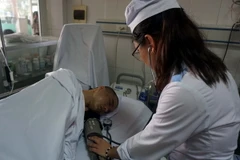 Nhân viên y tế Bệnh viện 115 Nghệ An chăm sóc một nạn nhân bị tai nạn. (Ảnh: Bích Huệ/TTXVN)