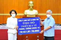 Chủ tịch Ủy ban Trung ương Mặt trận Tổ quốc Việt Nam Việt Nam Đỗ Văn Chiến tiếp nhận tượng trưng số tiền hơn 5 tỷ 800 triệu đồng từ Công ty TNHH Minh Tâm. (Ảnh: Minh Đức /TTXVN)