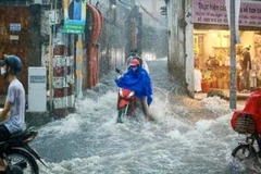 Sóng nước cuồn cuộn trên đường Võ Văn Ngân, thành phố Thủ Đức. (Ảnh: Hồng Giang/TTXVN)