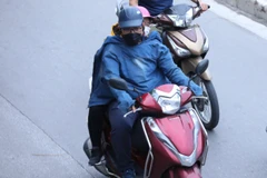 Người dân đã phải mặc thêm áo chống lại cái lạnh đầu mùa.(Ảnh: Hoàng Hiếu/TTXVN) 