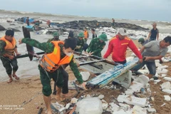 Lực lượng Biên phòng tỉnh Phú Yên hỗ trợ ngư dân trục vớt thân tàu. (Ảnh: Tường Quân/TTXVN)