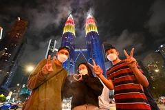 Người dân Malaysia chào đón Năm mới 2022 bên Toà tháp đôi ở Kuala Lumpur, ngày 31/12/2021. (Ảnh: THX/TTXVN) 