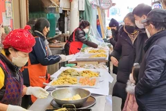 Khách hàng mua món chiên hải sản chế biến sẵn. (Ảnh: Khánh Vân/TTXVN) 