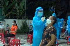 Nhân viên y tế Nghệ An xuyên đêm lấy mẫu xét nghiệm đối với những trường hợp liên quan đến các ca bệnh. (Ảnh: Văn Tý/TTXVN) 