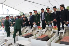 Nguyên Chủ tịch nước Trương Tấn Sang và lãnh đạo tỉnh Hà Giang cùng các đại biểu dự lễ an táng hài cốt liệt sỹ tại Nghĩa trang Liệt sỹ Quốc gia Vị Xuyên. (Ảnh: Minh Tâm/TTXVN)