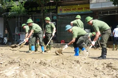 Hàng trăm người gồm bộ đội, công an, dân quân tự vệ, đoàn thanh niên... được huy động hỗ trợ dọn bùn, giúp người dân thành phố Yên Bái sớm ổn định cuộc sống sau đợt lũ. (Ảnh: Tuấn Anh/TTXVN)