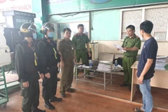 Lực lượng chức năng thông qua biên bản khám xét Trạm xăng dầu 233 và nơi ở của Bùi Ngọc Toàn. (Ảnh: TTXVN phát)