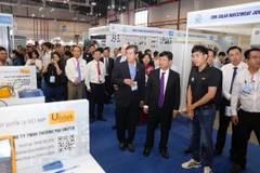 Lãnh đạo tỉnh Bình Dương và các quan khách tham quan các triển lãm. (Ảnh: Huyền Trang/TTXVN)