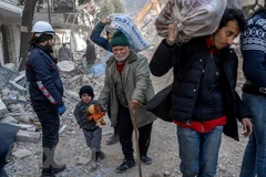 Người dân di chuyển giữa đống đổ nát sau trận động đất. (Ảnh: AFP/TTXVN)