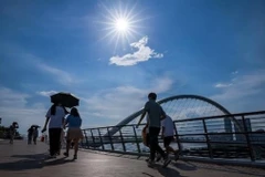 Người dân che ô tránh nắng trên đường phố tại tỉnh Phúc Kiến, Trung Quốc. (Ảnh: AFP/TTXVN)