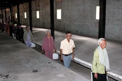 Các cựu tù thăm lại nơi bị giam giữ trước đây. (Ảnh: Quách Lắm/TTXVN) 