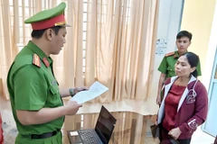 Cơ quan Cảnh sát điều tra tống đạt quyết định khởi tố bị can Phan Thị Nhiệm. (Ảnh: Trọng Nguyễn/TTXVN)