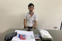 Đối tượng Hoàng Văn Thoa cùng tang vật. (Ảnh TTXVN)