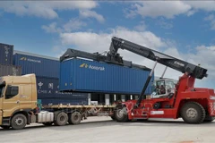 Bốc xếp hàng hóa tại huyện Hadxaiphon. (Ảnh: Đỗ Bá Thành/TTXVN)