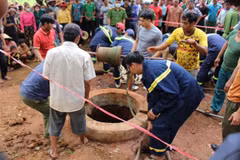 Lực lượng cứu hộ phối hợp với người dân trục vớt thi thể 2 nạn nhân. (Ảnh: TTXVN phát)