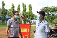 Đo thân nhiệt cho người vào tỉnh Đắk Lắk tại chốt kiểm soát phòng, chống dịch COVID-19 trên Quốc lộ 14. (Ảnh: Tuấn Anh – TTXVN)