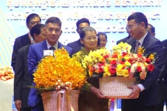 Tham tán Công sứ Ngô Văn Tuất (bên phải) chúc mừng Mặt trận Đoàn kết và Phát triển Tổ quốc Campuchia. (Ảnh: Hoàng Minh/TTXVN)