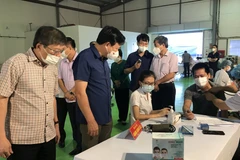 Bí thư Tỉnh ủy Hải Dương Phạm Xuân Thăng kiểm tra công tác khám sàng lọc trước khi tiêm. (Ảnh: Tiến Vĩnh/TTXVN)