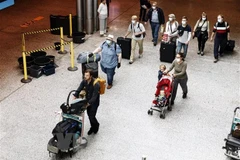 Hành khách đeo khẩu trang phòng lây nhiễm COVID-19 tại sân bay Canada. (Ảnh: AFP/TTXVN) 