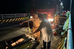 Lực lượng lượng chức năng cứu hộ, cứu nạn các nạn nhân trong vụ tai nạn. (Ảnh TTXVN phát)