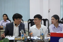 Ông Phan Phiến, Hiệu trưởng Trường Đại học Khánh Hòa trao đổi cùng hai du học sinh Lào, học năm thứ 2 tại Trường. (Ảnh: Phan Sáu/TTXVN)