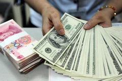 Kiểm đếm đồng USD và nhân dân tệ. (Ảnh: AFP/TTXVN)