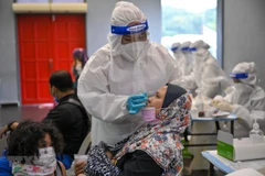 Nhân viên y tế lấy mẫu xét nghiệm COVID-19 cho người dân tại Kuala Lumpur, Malaysia. (Ảnh: AFP/TTXVN) 