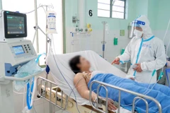 Bác sĩ Hồ Viết Thắng, Trưởng khu K1 (khu điều trị bệnh nhân COVID-19) Bệnh viện Hùng Vương thăm sản phụ N.T.L. (Ảnh: Thiên Chương.)