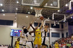 Pha tranh bóng trong trận Nha Trang Dolphins (áo vàng) và Saigon Heat (áo trắng). (Ảnh: Tiến Lực/TTXVN)